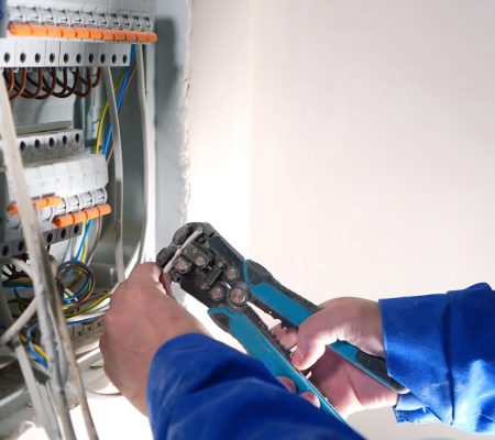 Electrician works with internet cable conneting. Electrical switchboard with automats and wires.
